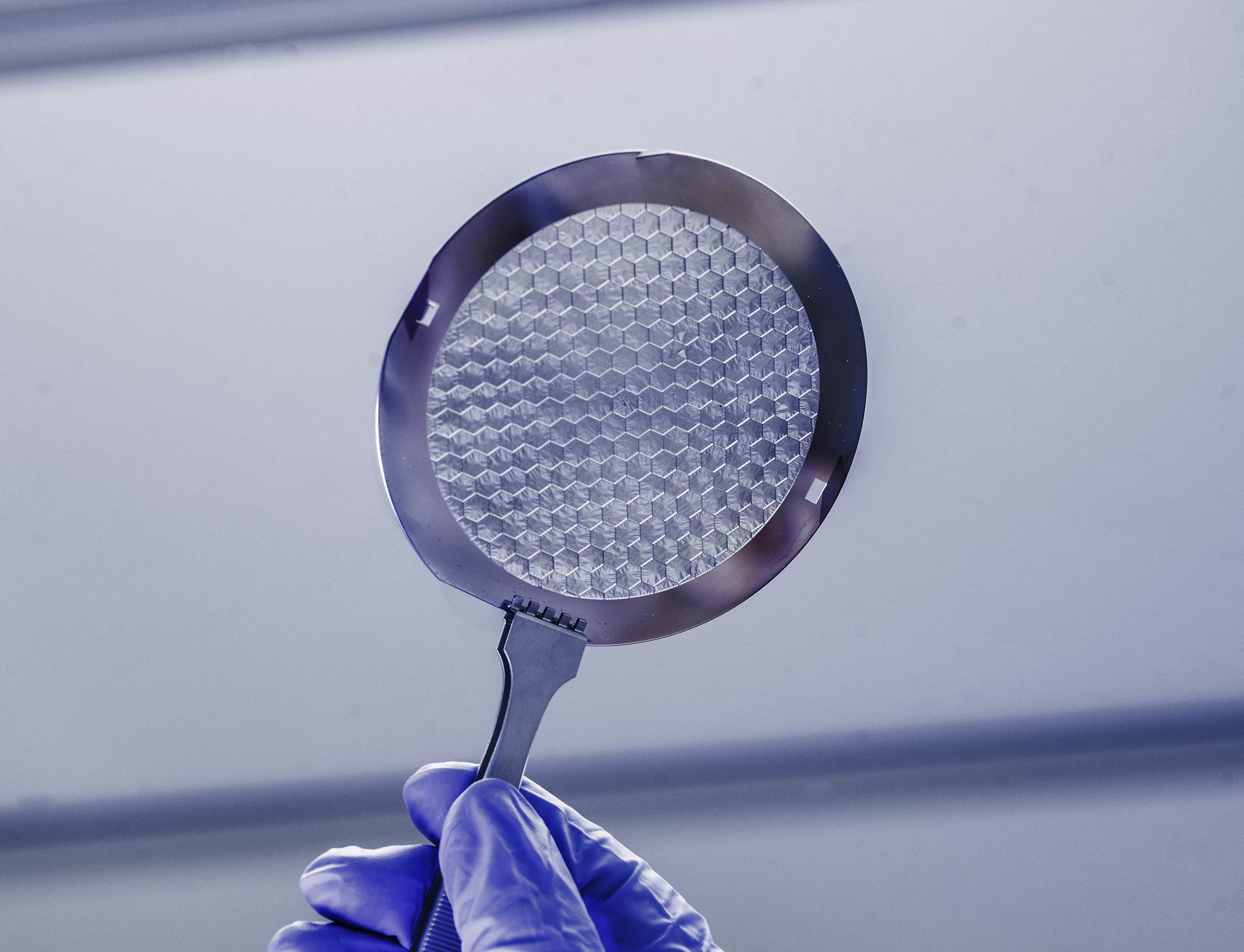 an 8-inch wafer of silicon, with hair-thin panels etched with microscopic holes.