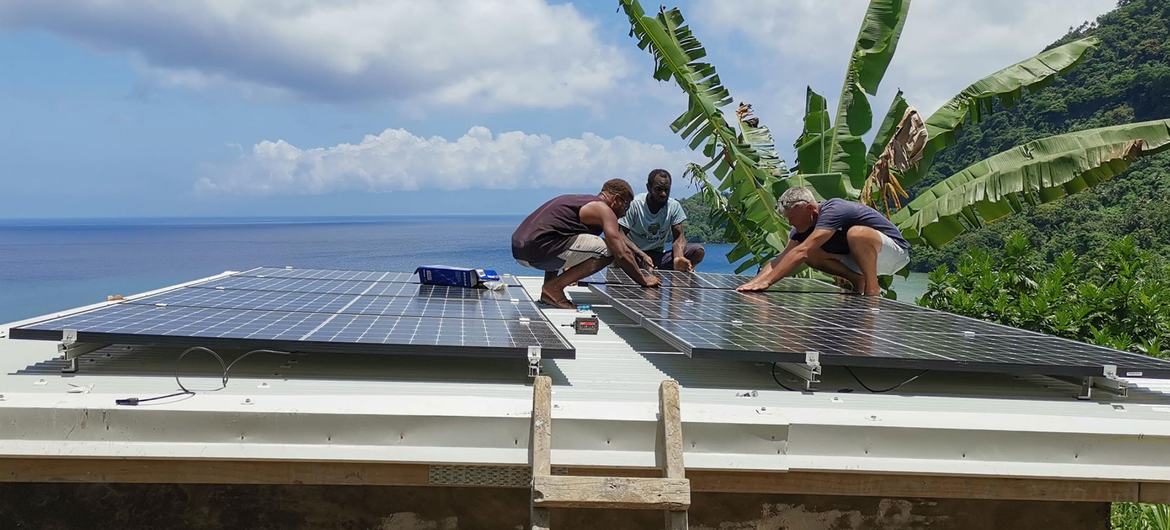 People in Vanuatu in the southwestern Pacific install solar panels on a roof. People in Vanuatu in the southwestern Pacific install solar panels on a roof.