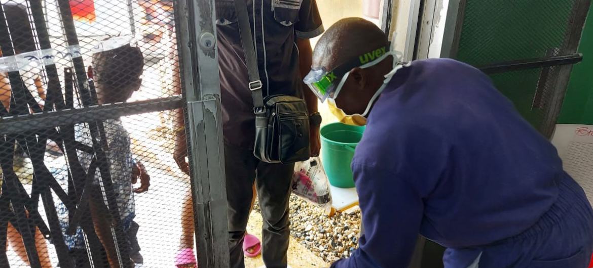 A health worker carries out sanitation procedures as people enter a cholera facility in Haiti. A health worker carries out sanitation procedures as people enter a cholera facility in Haiti.
