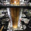 Image shows orange rocket stage with two large solid rocket boosters stacked alongside on March 23.