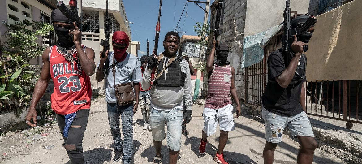 Gang members walk through a neighbourhood in Port-au-Prince. Gang members walk through a neighbourhood in Port-au-Prince.
