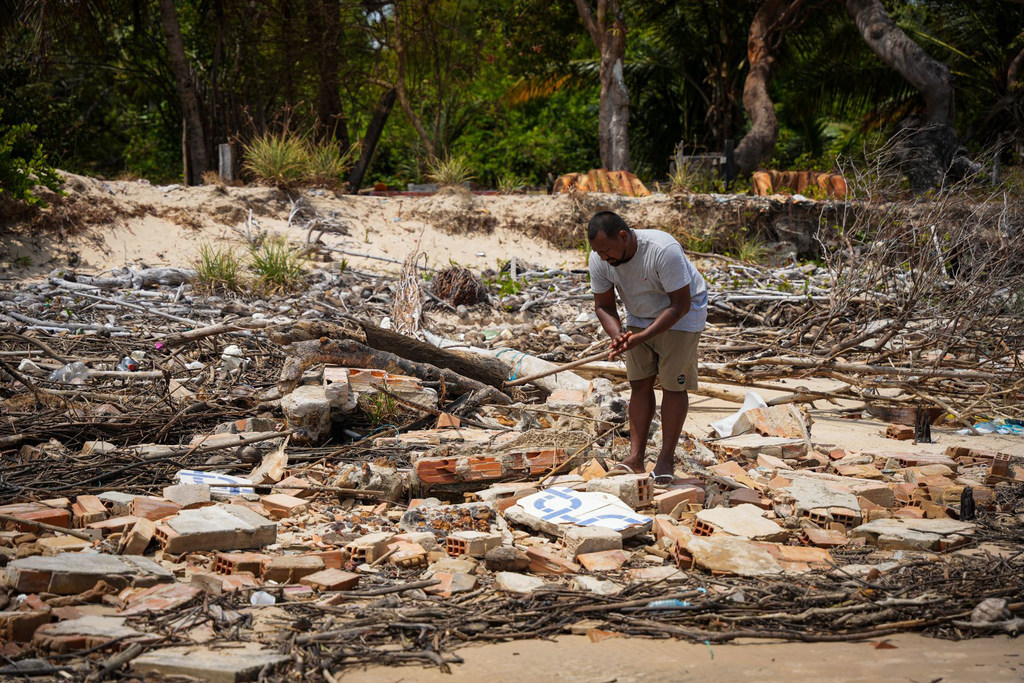 Jhonny, Ivanil’s son, searches through the rubble of destroyed houses.