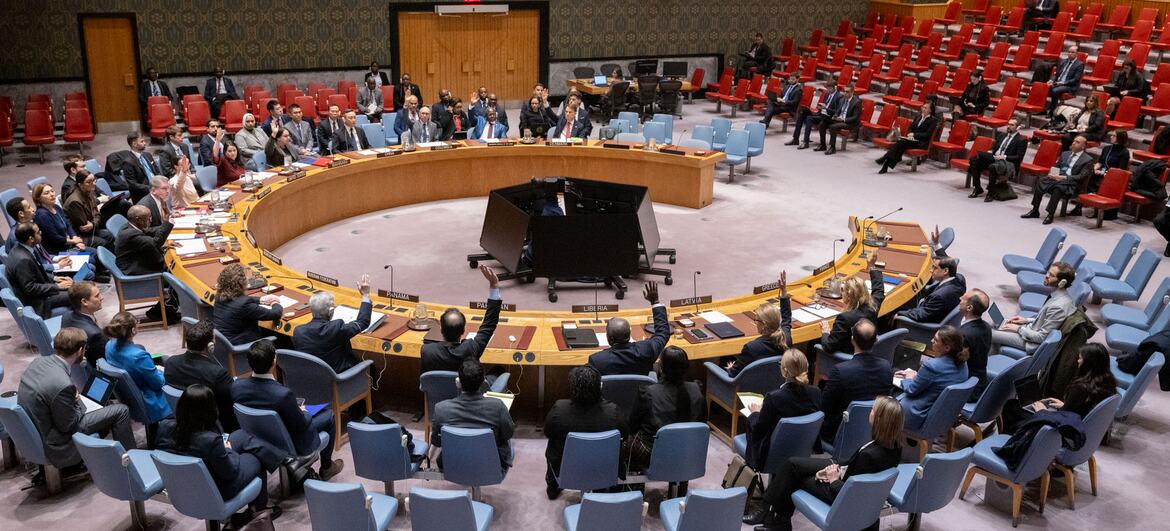 Wide view of the United Nations Security Council voting on a resolution regarding international peace and security in the Red Sea, with delegates raising their hands to indicate approval.