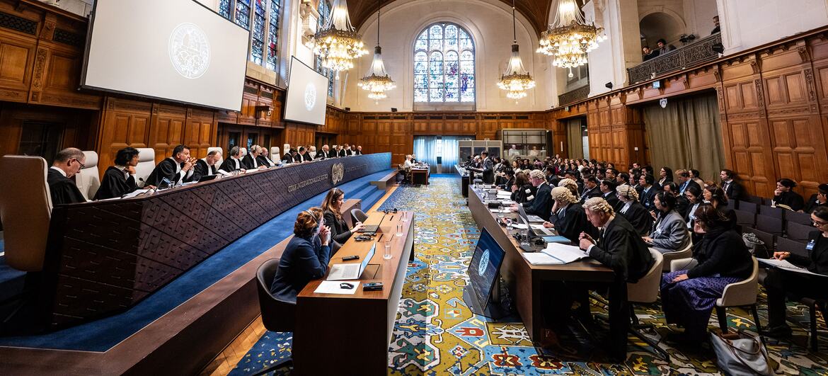 The International Court of Justice (ICJ) holds public hearings on the genocide case between The Gambia and Myanmar at the Peace Palace in The Hague, with judges seated at a long table and attendees in the audience.