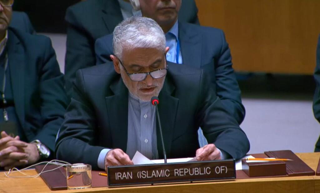 A male diplomat from Iran (Islamic Republic of) speaking at an international conference, reading from a document at a podium with his country's nameplate.