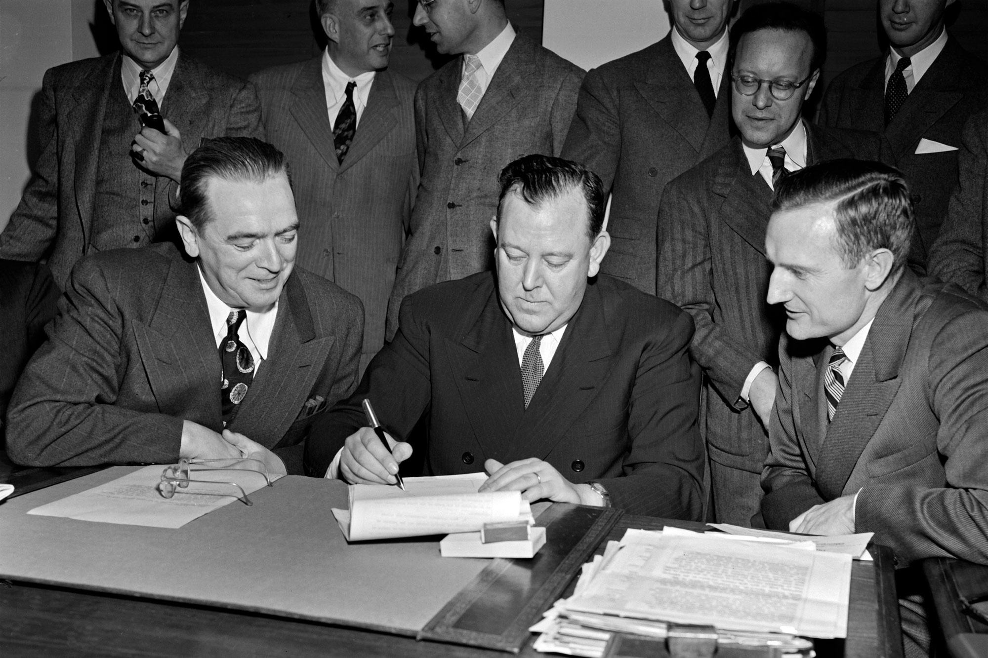 UN Secretary-General Trygve Lie (centre) accepts a gift of $8.5 million in March 1947 for the purchase of land on the East River in Manhattan.