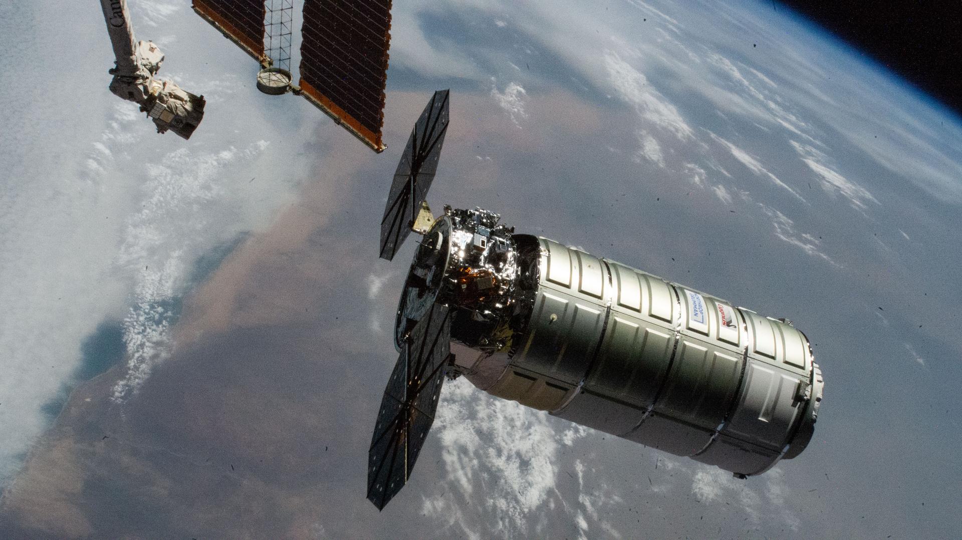 Northrop Grumman's Cygnus XL cargo craft, carrying over 11,000 pounds of new science and supplies for the Expedition 73 crew, is pictiured moments before its capture with the International Space Station's Canadarm2 robotic arm. Both spacecraft were orbiting 257 miles above Namibia. Cygnus XL is Northrop Grumman's expanded version of its previous Cygnus cargo craft increasing its payload capacity and pressurized cargo volume.