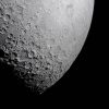 Part of the Moon stands out against the blackness of space. Its surface is marked with many craters of different sizes. The craters are mostly on the left and bottom. The upper right portion of the Moon's surface is much smoother.