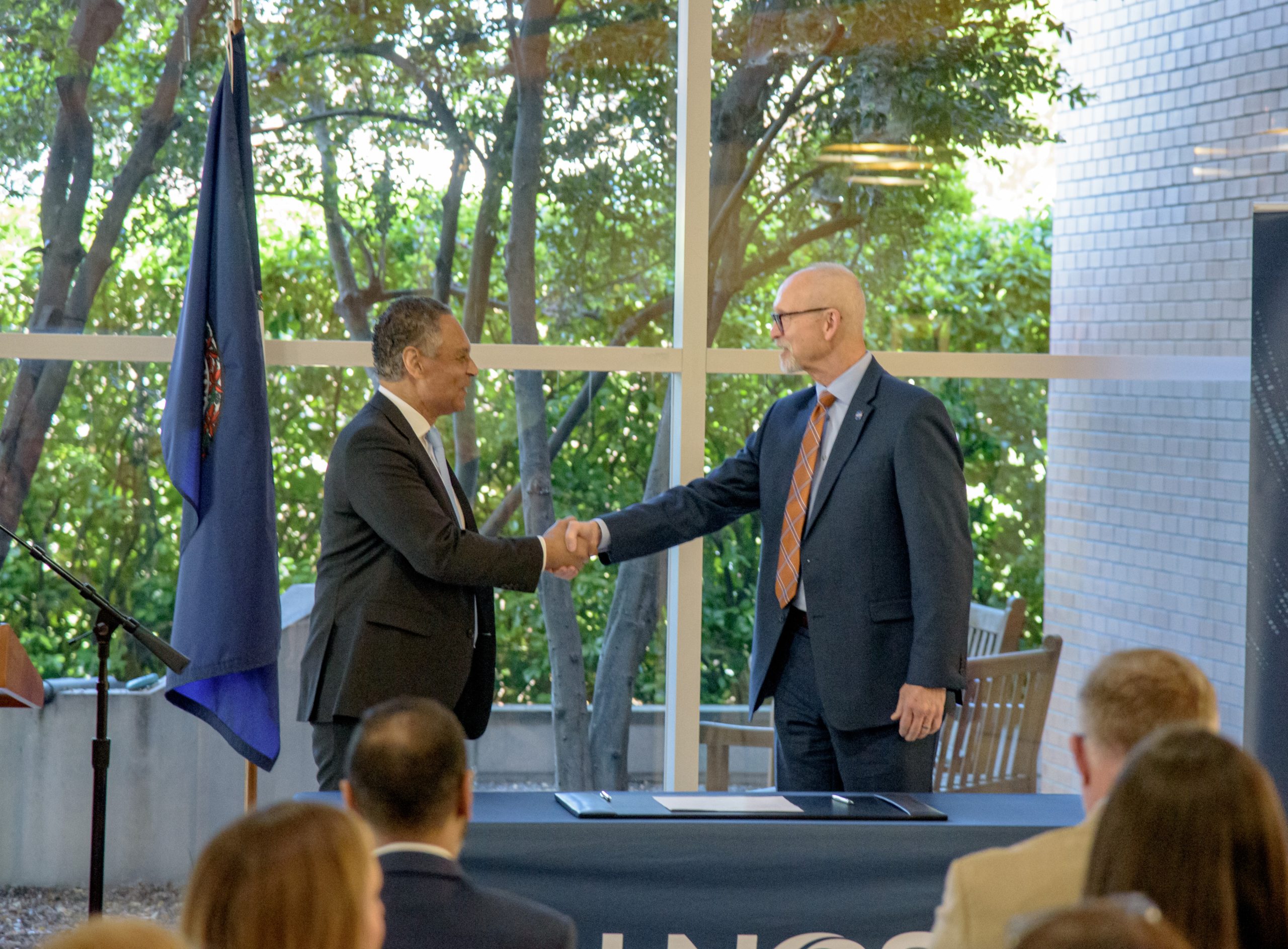 Mark Johnson, left, interim CEO of UNOS, and John Koelling, director of the Aeronautics Research Directorate at NASA's Langley Research Center, shake hands during a signing ceremony marking an agreement to study drone transport for organs.