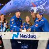 Nasdaq Chair and Chief Executive Officer Adena T. Friedman, left, and NASA’s Artemis II crewmembers CSA (Canadian Space Agency) astronaut Jeremy Hansen, and NASA astronauts Christina Koch, Victor Glover, and Reid Wiseman, right, ring the closing bell of the Nasdaq market session. They're standing behind a wide white podium with the Nasdaq logo and the word "Nasdaq." There is a screen on the front of the podium displaying the NASA meatball logo. Friedman is standing a little further away from the podium. Red, white, and blue confetti falls from the air on the left side of the image.